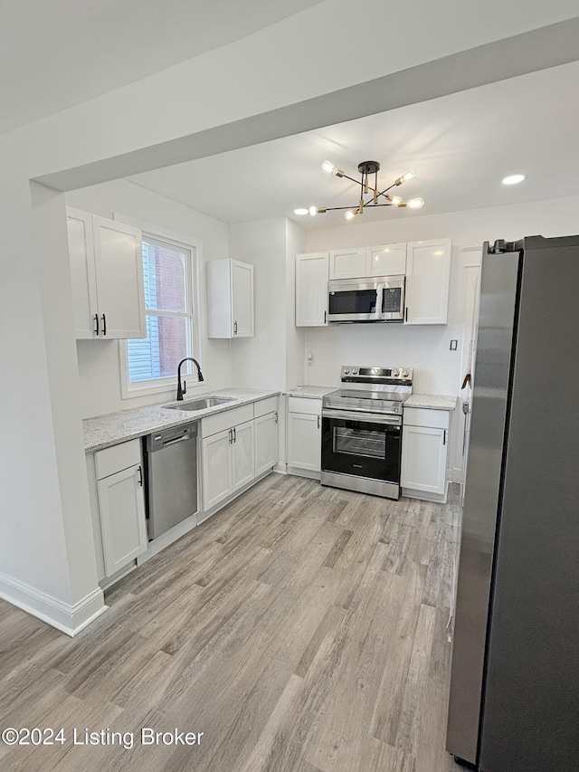 kitchen featuring white cabinets, light wood-type flooring, stainless steel appliances, and sink