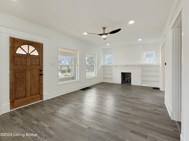 foyer featuring ceiling fan, dark hardwood / wood-style floors, and a brick fireplace