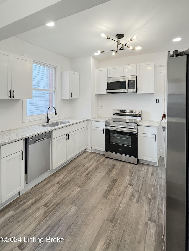 kitchen with white cabinetry, sink, light hardwood / wood-style flooring, and appliances with stainless steel finishes