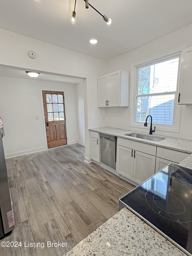 kitchen with dishwasher, white cabinets, sink, light hardwood / wood-style flooring, and range