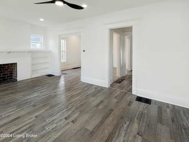 unfurnished living room featuring ceiling fan and dark wood-type flooring