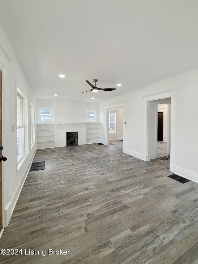 unfurnished living room featuring ceiling fan, a healthy amount of sunlight, and hardwood / wood-style flooring