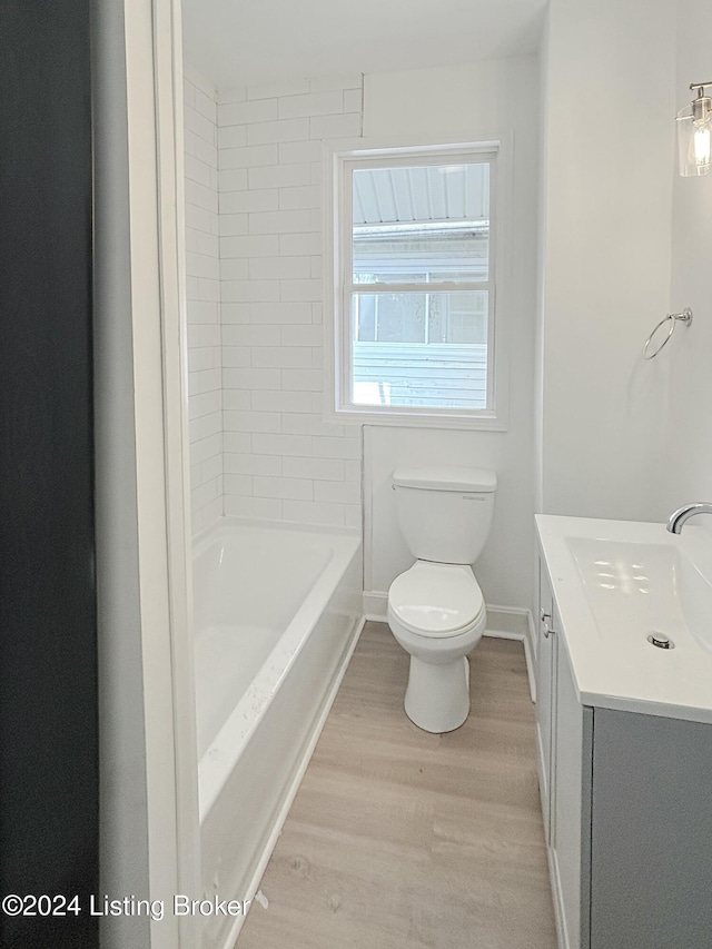 bathroom with wood-type flooring, vanity, and toilet