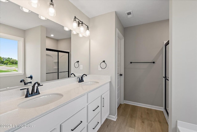 8801 Legendary Ln, Louisville, KY 40229 - bathroom with wood finished floors, a stall shower, baseboards, and double vanity