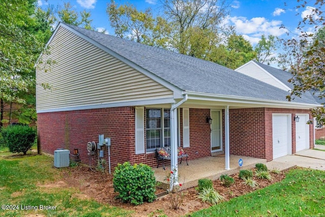 view of front facade with covered porch, central AC, and a garage