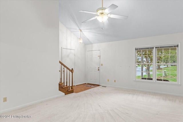 unfurnished living room with ceiling fan, carpet flooring, and vaulted ceiling