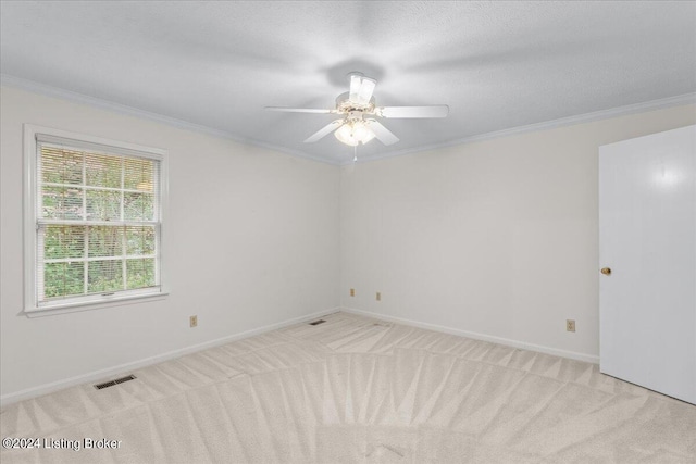 spare room featuring light carpet, ornamental molding, and ceiling fan