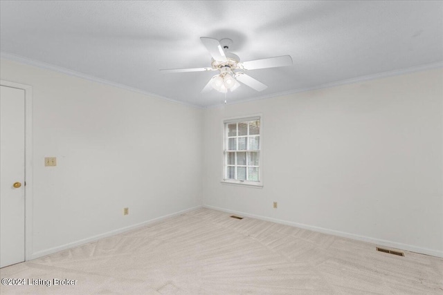 unfurnished room featuring crown molding, light carpet, and ceiling fan