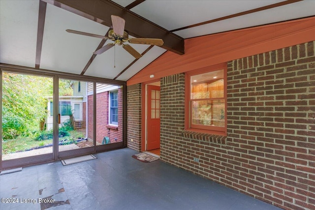 unfurnished sunroom with vaulted ceiling with beams and ceiling fan