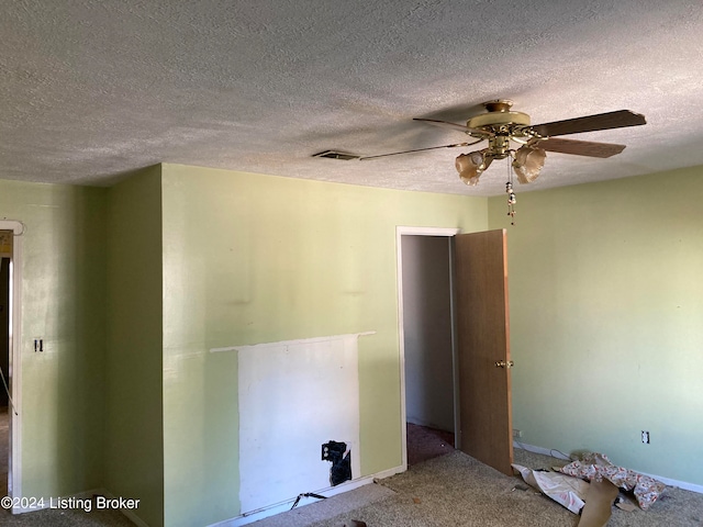 empty room with a textured ceiling, carpet, and ceiling fan