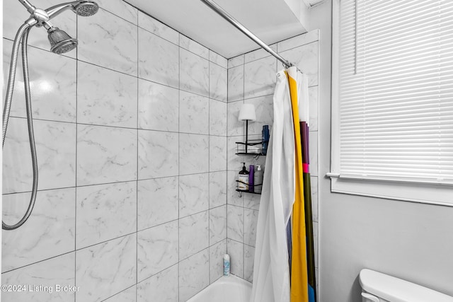 bathroom featuring toilet and shower / bath combo