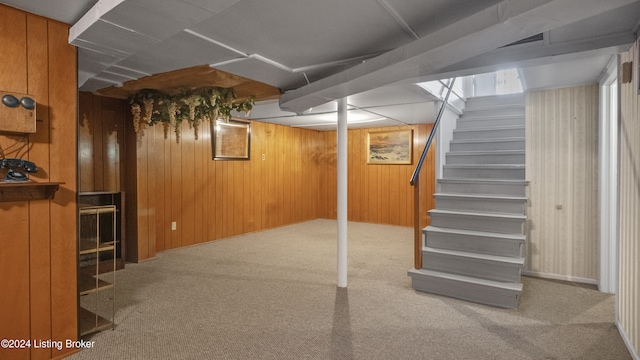 basement with carpet floors and wood walls