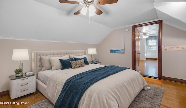 bedroom with ceiling fan, ornamental molding, lofted ceiling, and light wood-type flooring