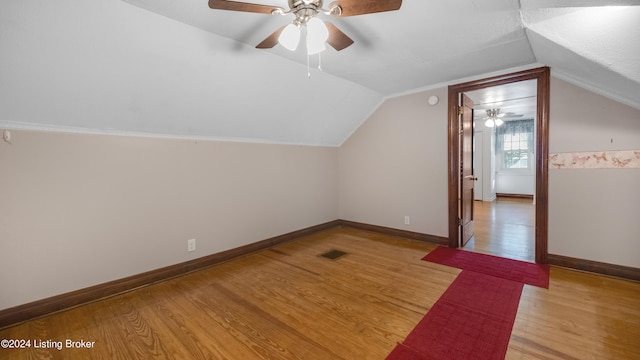 additional living space with ceiling fan, vaulted ceiling, and light wood-type flooring