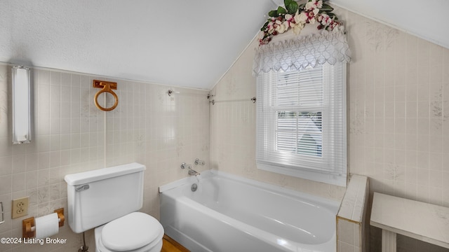 bathroom with tile walls, vaulted ceiling, and toilet