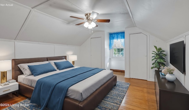 bedroom with ceiling fan, wood-type flooring, and vaulted ceiling