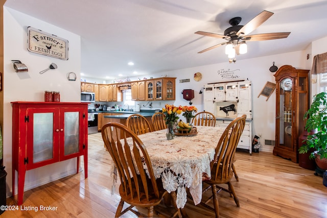 dining area with a healthy amount of sunlight, sink, light wood-type flooring, and ceiling fan