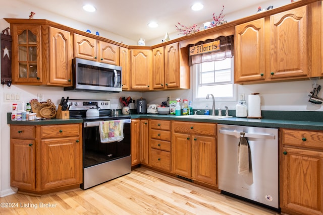 kitchen featuring appliances with stainless steel finishes, sink, and light wood-type flooring