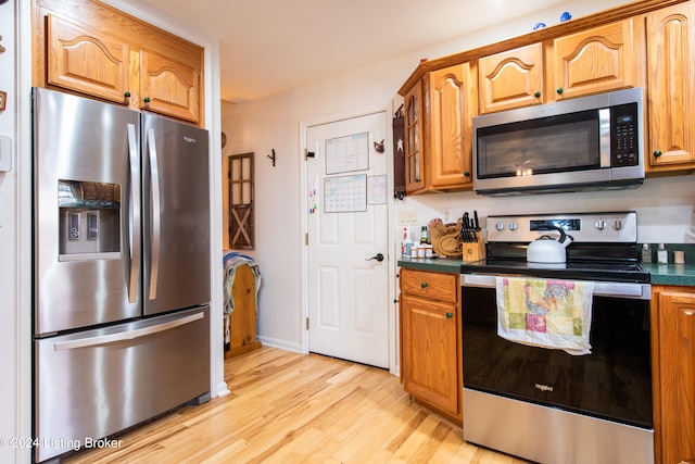 kitchen with appliances with stainless steel finishes and light hardwood / wood-style flooring