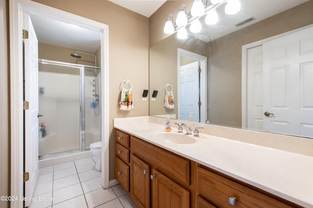 bathroom featuring vanity, toilet, walk in shower, and tile patterned flooring