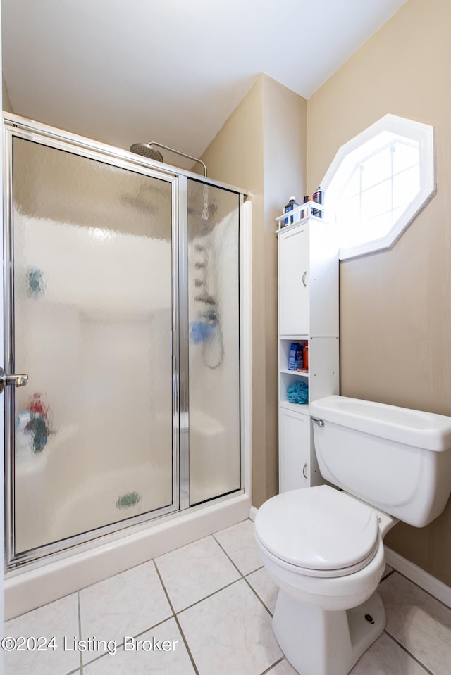 bathroom featuring tile patterned floors, toilet, and walk in shower