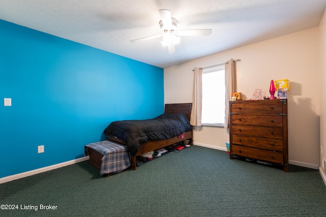 unfurnished bedroom with dark colored carpet, a textured ceiling, and ceiling fan