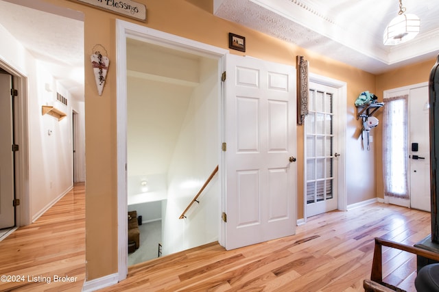 foyer entrance with a textured ceiling and light wood-type flooring