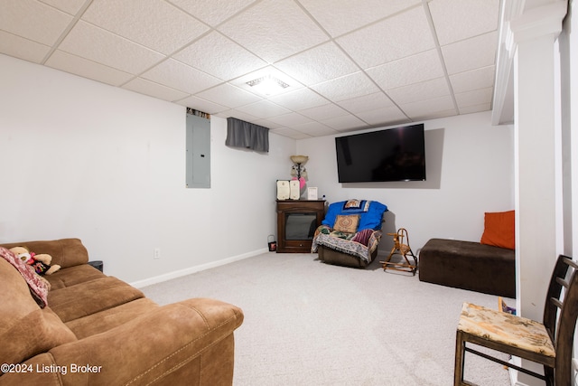 living room featuring a drop ceiling, electric panel, and carpet