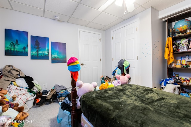 carpeted bedroom featuring a paneled ceiling and ceiling fan