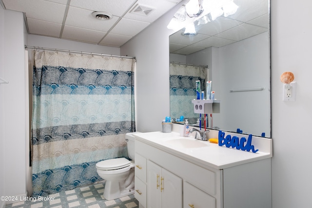 bathroom with vanity, a drop ceiling, toilet, and walk in shower