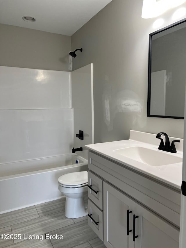 full bathroom featuring toilet, vanity, and shower / bathing tub combination