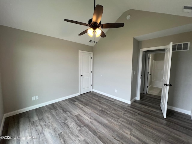 unfurnished bedroom with baseboards, visible vents, dark wood-style floors, and lofted ceiling
