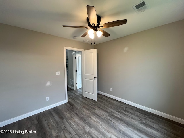 unfurnished bedroom with dark wood-type flooring, visible vents, a ceiling fan, and baseboards