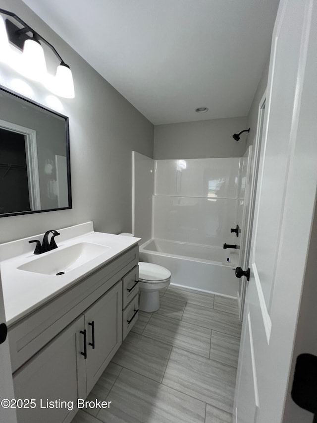 bathroom featuring toilet, vanity, and shower / bathing tub combination