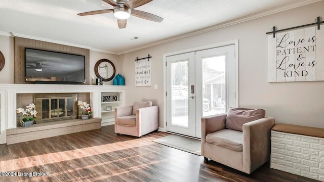 living area with french doors, hardwood / wood-style flooring, crown molding, a barn door, and ceiling fan