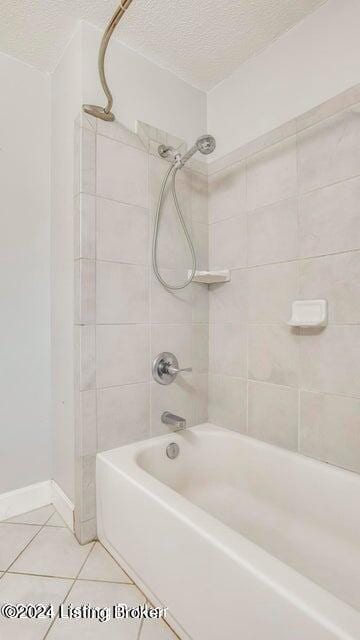 bathroom featuring tiled shower / bath combo, a textured ceiling, and tile patterned flooring