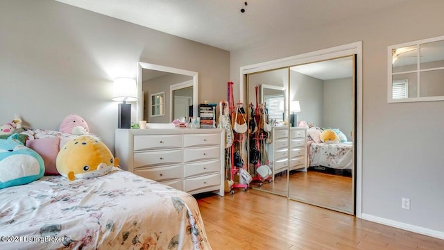 bedroom featuring a closet, multiple windows, and light wood-type flooring