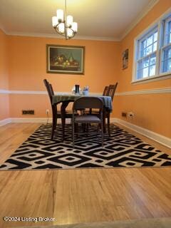 dining room featuring crown molding, a chandelier, and hardwood / wood-style floors