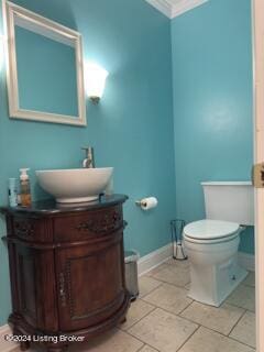 bathroom featuring vanity, toilet, crown molding, and tile patterned floors