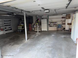 garage with white fridge and a garage door opener