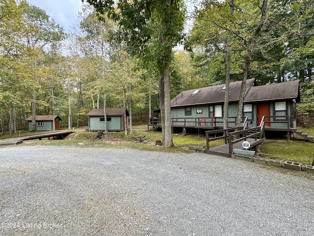 308 Oak Rd, Falls Of Rough, KY 40119 - view of front of home featuring a storage unit, a deck, roof with shingles, and view of wooded area