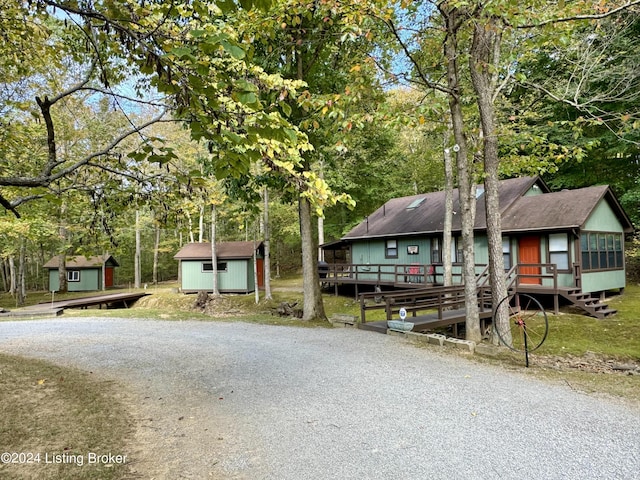308 Oak Rd, Falls Of Rough, KY 40119 - rustic home featuring a shed, roof with shingles, gravel driveway, view of wooded area, and a wooden deck