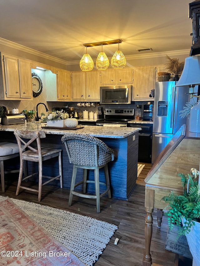 kitchen with appliances with stainless steel finishes, pendant lighting, dark wood-type flooring, light stone counters, and a breakfast bar area