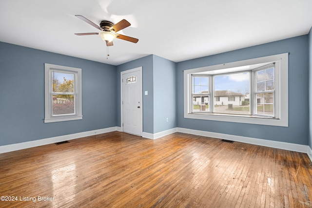 unfurnished room with ceiling fan, hardwood / wood-style flooring, and a healthy amount of sunlight