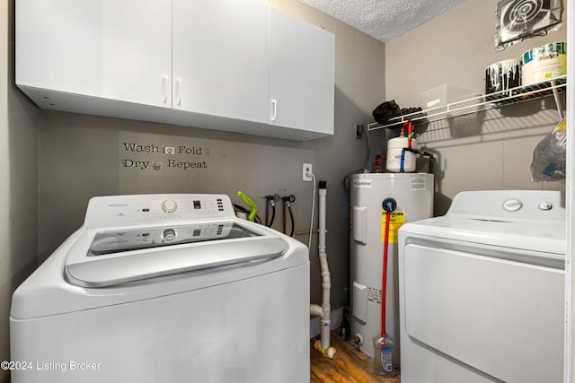 laundry room with cabinets, a textured ceiling, electric water heater, wood-type flooring, and separate washer and dryer