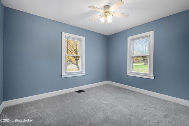 carpeted spare room with ceiling fan