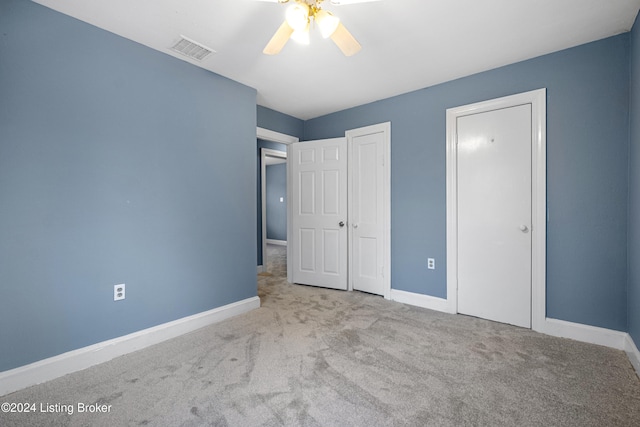 unfurnished bedroom with ceiling fan and light colored carpet