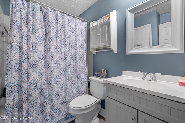 bathroom featuring vanity, a textured ceiling, toilet, and walk in shower