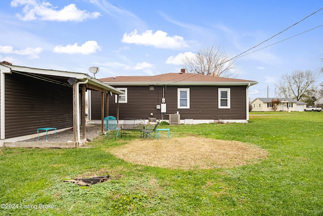 rear view of property with a yard and cooling unit