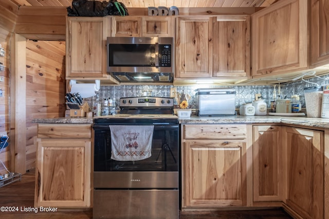 kitchen with light brown cabinetry, backsplash, appliances with stainless steel finishes, and light stone counters